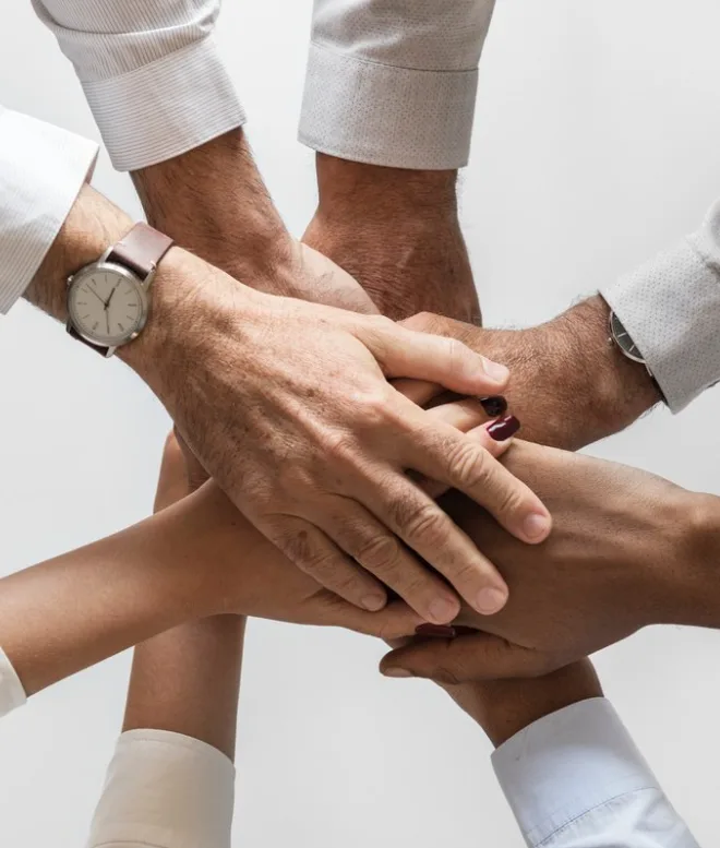Team members stacking their hands together in a circle